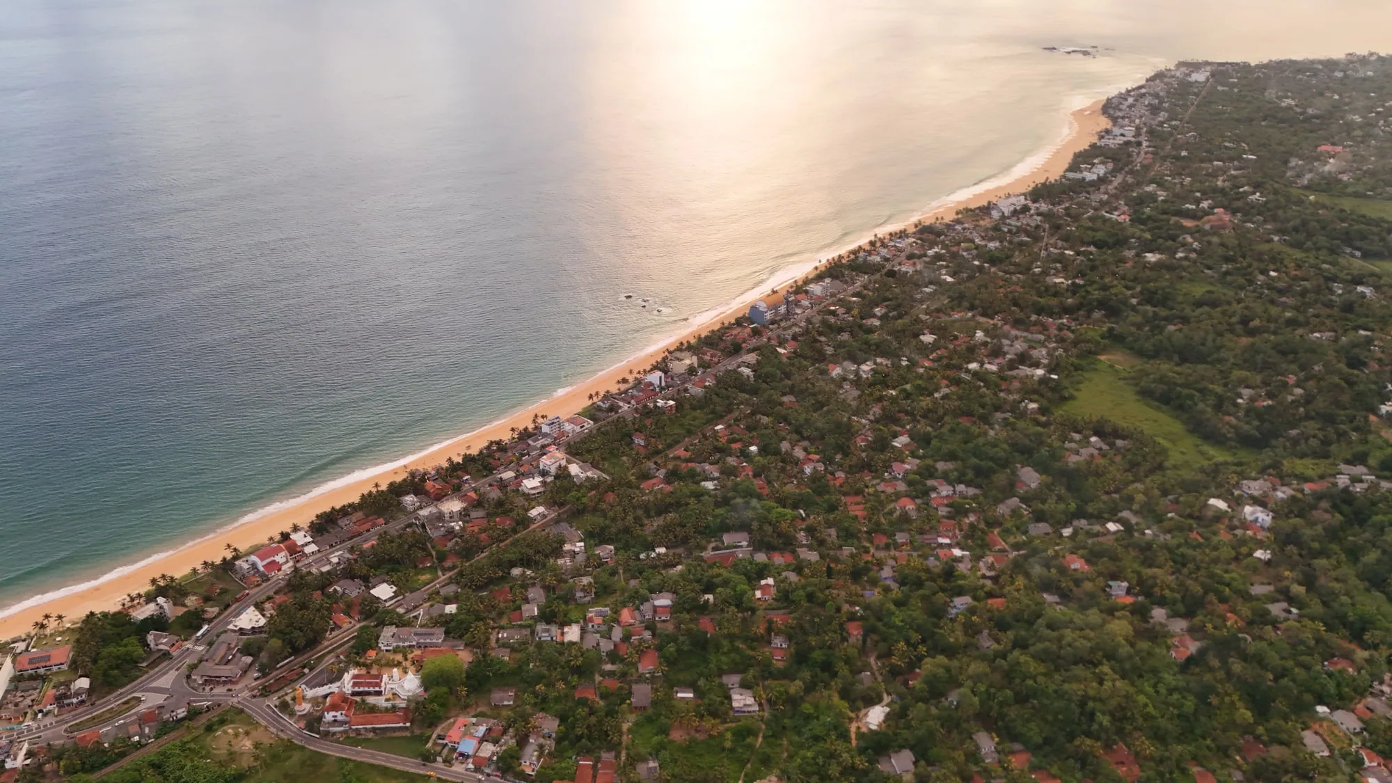 Aerial view of Hikkaduwa’s coastline, beach and palm-covered town