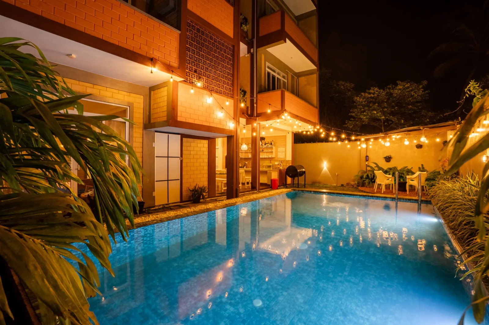 The villa’s swimming pool and terrace illuminated at dusk